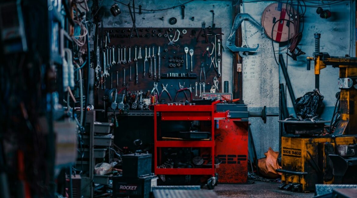 Red rolling tool cart stocked with hand tools in a garage workshop